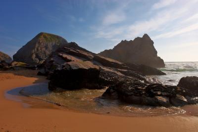Rock formations in the wet sand at Bedruthan Steps